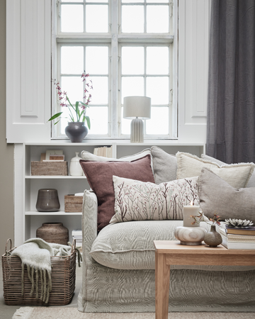 Nordiskt inrett vardagsrum med höstfärger, plädar och lyktor från Lene Bjerre