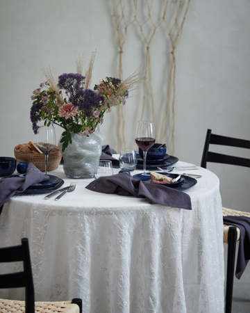 En romantisk Alla hjärtans dag-bordsdukning med röda rosor, levande ljus och elegant porslin som skapar en mysig och kärleksfull atmosfär.